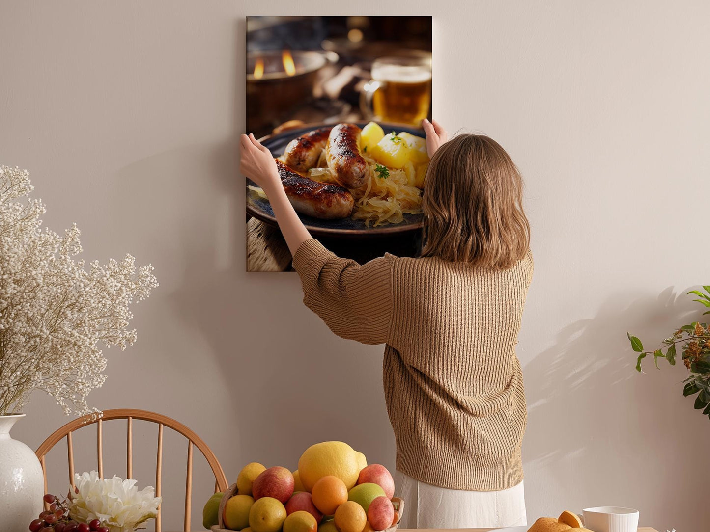 A woman hangs a framed photograph of a plate of food on a wall in a cozy kitchen setting.