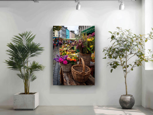 a vibrant street scene with a variety of colorful flowers and plants displayed in baskets, creating a lively and inviting atmosphere.