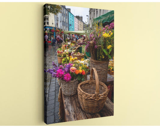 A vibrant street market with a variety of colorful flowers and baskets displayed on tables and in baskets.