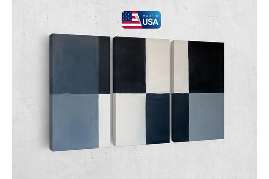 a white wall with a black and gray wall hanging on it