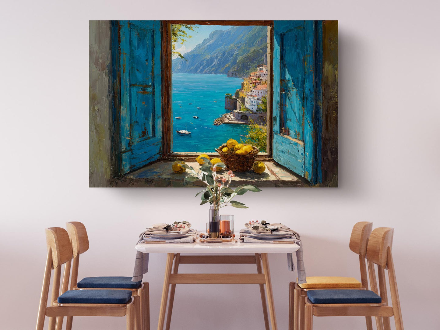 a dining table set with plates, silverware, and a vase of flowers, with a painting of a coastal town and a view of the sea hanging above it.