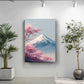 a serene indoor setting with a large potted plant on the left side and a framed painting of a mountain with pink flowers on the right side. The painting is hung on a white wall, and the potted plant is placed on a white floor.