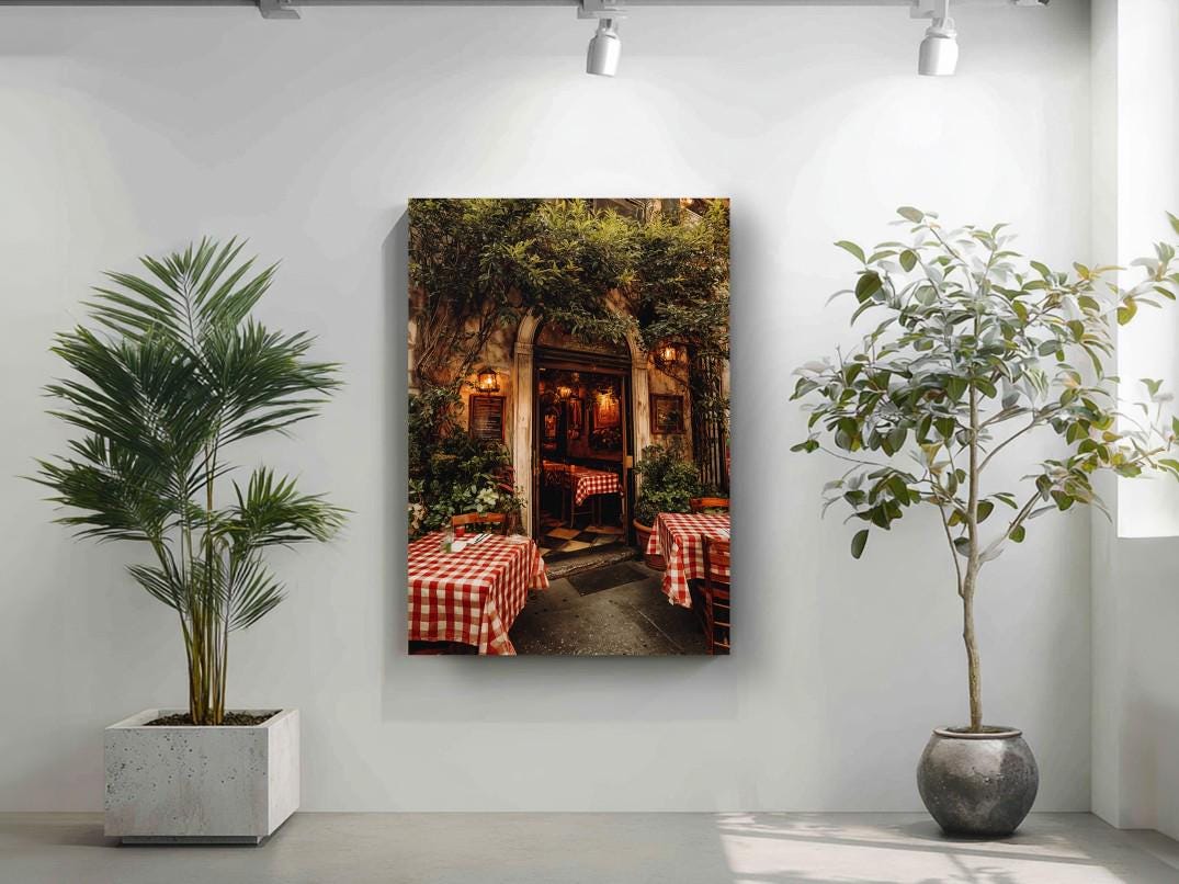 a cozy outdoor dining area with tables and chairs, surrounded by lush greenery and illuminated by warm lighting.