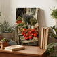 a wooden table with a variety of potted plants, a stack of books, and a painting of tomatoes and lavender.