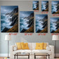 The image is a living room with a white sofa and a coffee table. Above the sofa, there are six framed pictures of ocean landscapes, each with a different size and resolution, ranging from 8 x 12 to 20 x 30 inches. The pictures are arranged in a grid-like pattern on the wall, creating a visually appealing display.