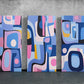 three abstract paintings on a concrete wall