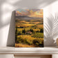 a painting of a picturesque countryside landscape, with rolling hills, vineyards, and a small village nestled among the greenery. The painting is displayed on a white shelf, with two vases placed to the right of it.