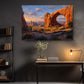 a large painting of a desert landscape with a prominent rock formation, hanging on a wall above a wooden desk with a lamp and some decorative items.