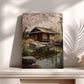 A serene Japanese garden scene with a traditional wooden house surrounded by a pond, lush greenery, and pink cherry blossoms in full bloom.