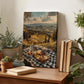 a wooden table with a checkered tablecloth, a picnic basket filled with food, and several potted plants. In the background, there is a framed landscape photograph depicting a scenic countryside view.