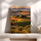 a picturesque countryside landscape with rolling hills, vineyards, and a small village nestled among the trees. The scene is bathed in warm, golden light, creating a serene and idyllic atmosphere.