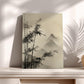 a minimalist art piece with a bamboo tree design and a misty mountain landscape in the background, displayed on a white shelf against a white wall.