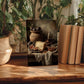 a wooden table with a framed photograph of a still life arrangement, including a vase of flowers, a bowl of fruit, and a book.