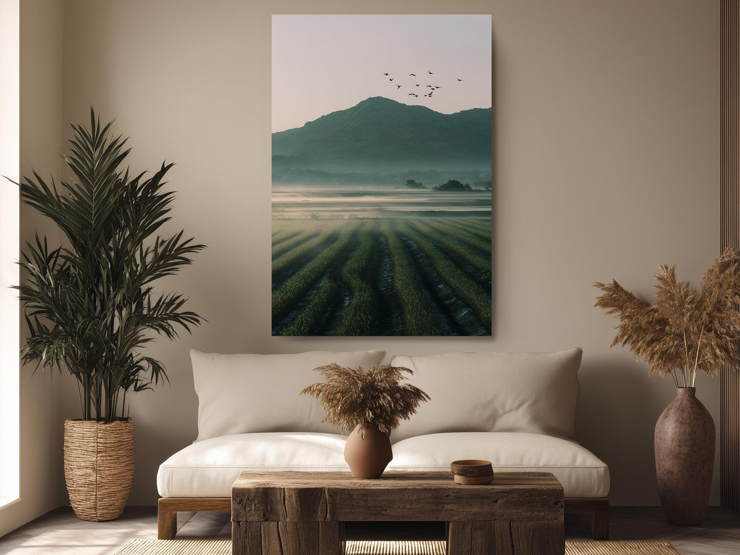 a serene living room with a large painting of a field of crops hanging on the wall, a sofa, a coffee table, and two potted plants.