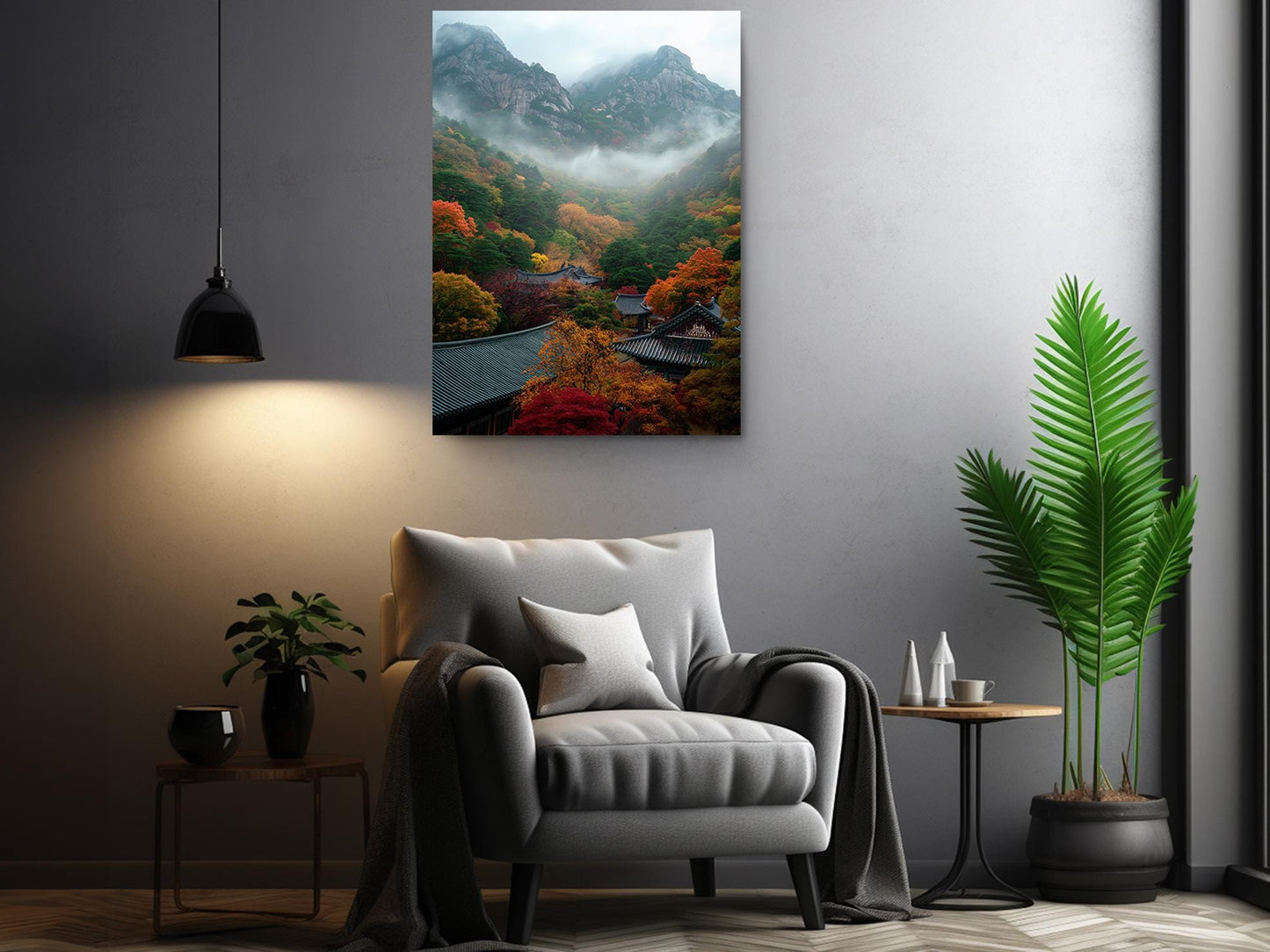 a cozy living room with a gray armchair, a wooden side table, and a potted plant. Above the armchair, there is a framed photograph of a mountainous landscape with a misty, colorful scene.
