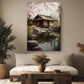a serene living room with a large painting of a Japanese-style house with a pond and cherry blossoms hanging on the wall. The painting is surrounded by various decorative elements, including potted plants, vases, and a wooden coffee table.
