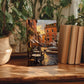 a wooden table with a framed painting of a street scene, surrounded by potted plants and books.