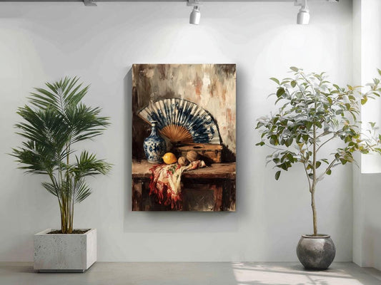 a still life painting of a table with a vase, fan, and fruit, including an orange and a pear, set against a white wall. The painting is hung on the wall, and there are two potted plants in the foreground, one on the left and one on the right.