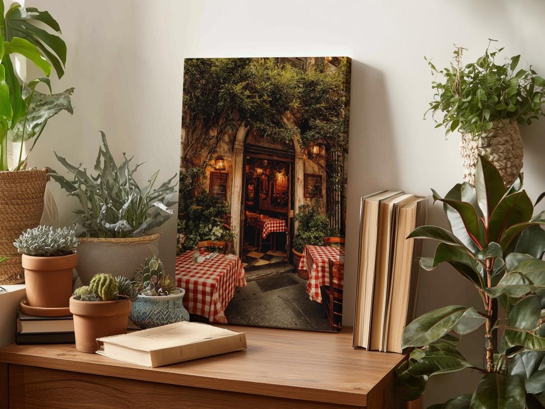 a cozy and inviting scene of a restaurant with a red and white checkered tablecloth, surrounded by lush greenery and potted plants. A framed photograph of the restaurant entrance is displayed on a wooden shelf, adding a touch of charm and warmth to the space.