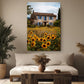 a cozy living room with a large window, a comfortable sofa, and a wooden coffee table. Above the sofa, there is a large canvas print depicting a picturesque house surrounded by a field of sunflowers.