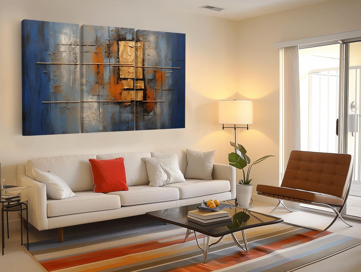 a living room with a white couch and a painting on the wall