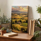 a wooden table with a painting of a countryside landscape, a stack of books, and several potted plants.