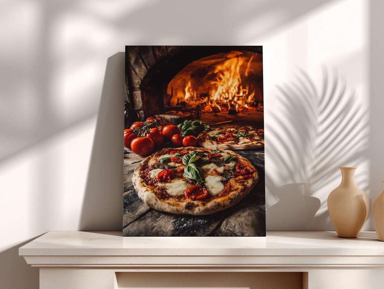 A framed photograph of a pizza with fresh basil and tomatoes, placed on a wooden surface, with a brick oven visible in the background.