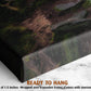 The image is a close-up of a canvas print featuring a forest scene with moss and rocks. The print is wrapped over a wooden frame and has a sawtooth hanger, indicating it is ready to hang.