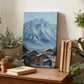 a wooden desk with a painting of a mountain village, a stack of books, and several potted plants.