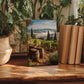 a wooden table with a framed photograph of a vineyard, a woven basket, and a stack of books.