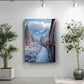 a snowy mountain landscape with a train traveling through it, as depicted in a framed artwork hanging on a wall.