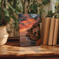 a wooden table with a framed photograph of a coastal landscape, surrounded by potted plants and books.