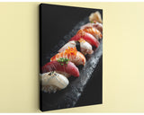 A close-up image of a variety of sushi rolls on a black plate, showcasing the vibrant colors and textures of the ingredients.