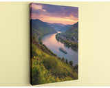 a picturesque river winding through a lush, green valley, with a small boat sailing on the water. The sky above is a beautiful gradient of orange and purple, creating a stunning backdrop for the scene. The overall composition is visually appealing and captures the essence of a serene, natural landscape.