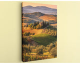 The image is a scenic landscape featuring rolling hills, vineyards, and a small village in the distance, all bathed in warm, golden light.