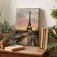 a wooden desk with a painting of the Eiffel Tower in the background, surrounded by potted plants and books.