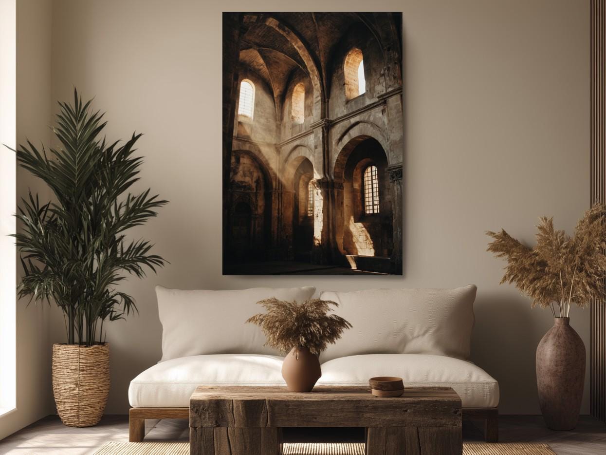 a cozy living room with a large, ornate painting of a historic building hanging on the wall. The room is decorated with a white sofa, a wooden coffee table, and two potted plants. The overall atmosphere of the room is warm and inviting, with the painting serving as a focal point.