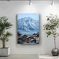 a large painting of a snowy mountain landscape with a quaint village in the foreground, hanging on a white wall. Two potted plants are placed on either side of the painting, adding a touch of greenery to the scene.