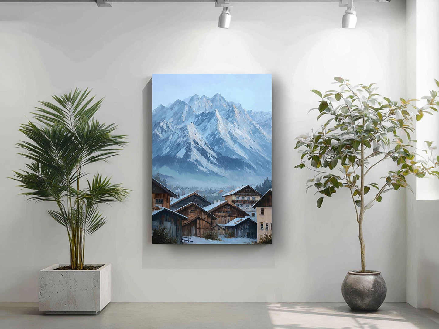 a large painting of a snowy mountain landscape with a quaint village in the foreground, hanging on a white wall. Two potted plants are placed on either side of the painting, adding a touch of greenery to the scene.