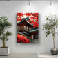 a large, colorful painting of a traditional Korean building with red leaves on its roof, hanging on a white wall. To the left of the painting, there is a potted plant, and to the right, there is another potted plant.