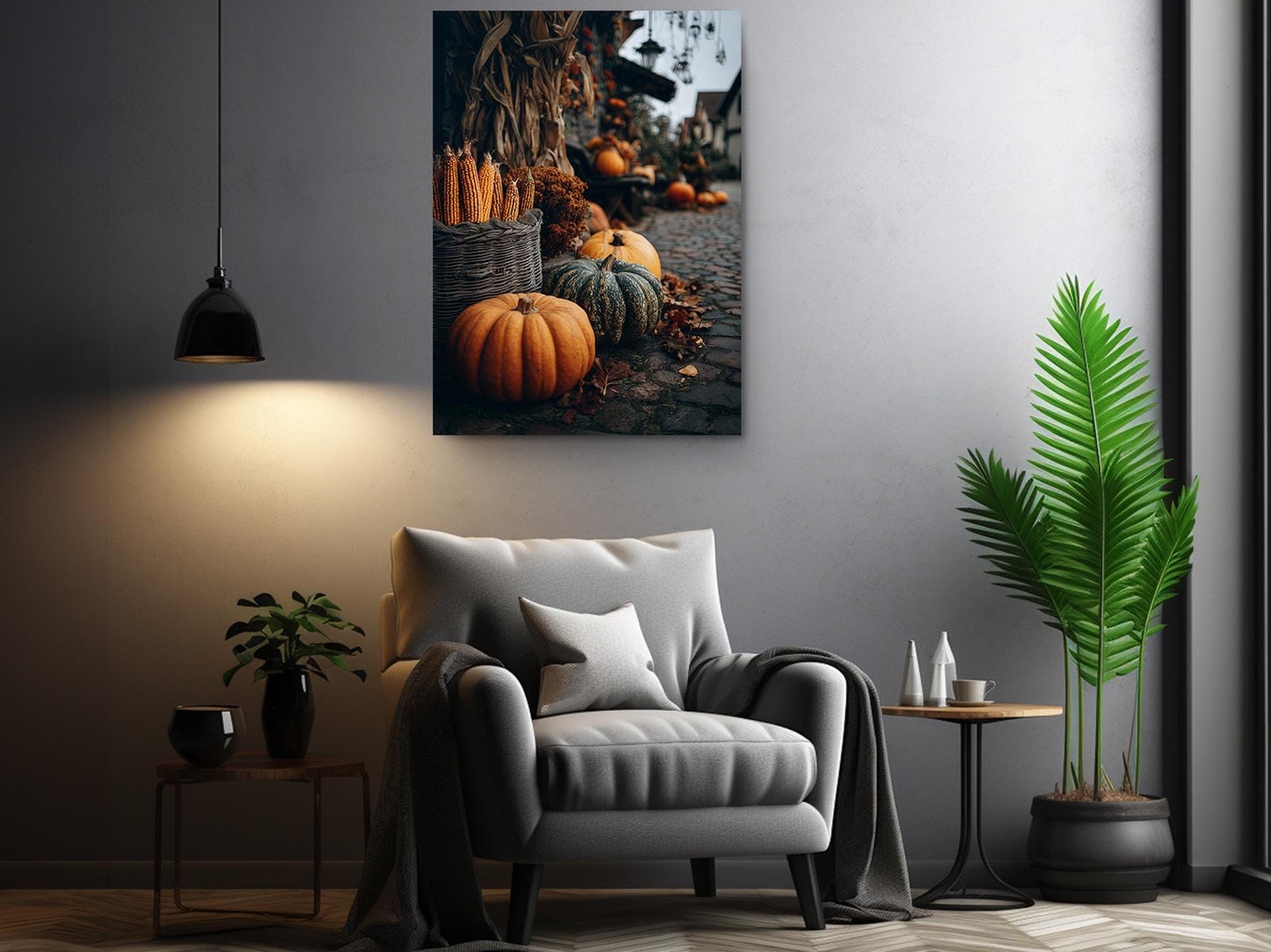 a cozy living room with a gray armchair, a potted plant, and a hanging lamp. Above the armchair, there is a framed photograph of pumpkins and gourds on a cobblestone path, creating a warm and inviting atmosphere.
