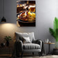 a cozy living room with a comfortable gray armchair, a wooden side table, and a potted plant. Above the armchair, there is a framed photograph of a plate of sausages and sauerkraut, creating a warm and inviting atmosphere.