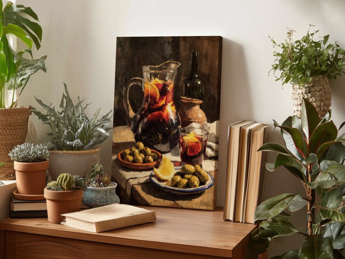 a wooden table with a painting of a still life scene, including a pitcher of wine, a bowl of olives, and a glass of orange juice. The table also has several potted plants, books, and other decorative items.