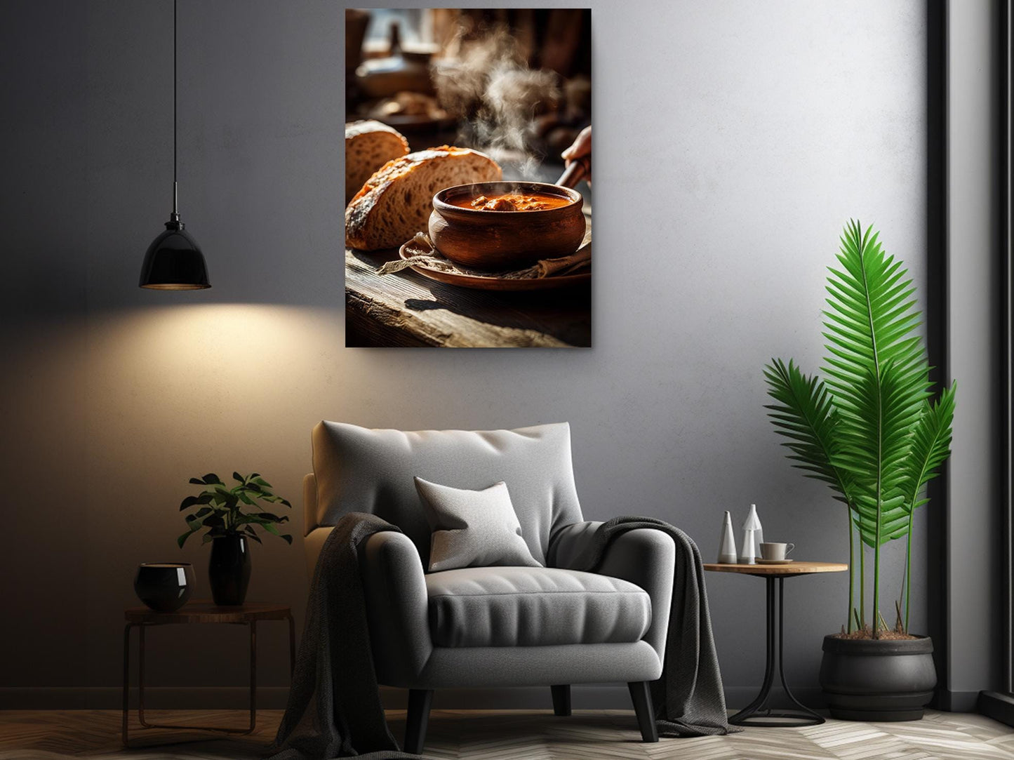 a cozy living room with a comfortable gray armchair, a wooden side table, and a potted plant. Above the armchair, there is a framed photograph of a bowl of soup on a wooden surface, with steam rising from it.