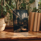 a wooden table with a framed photograph of a church interior, surrounded by potted plants and books.