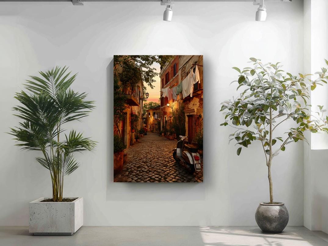 a narrow cobblestone street lined with buildings and trees, with a motorcycle parked on the side.