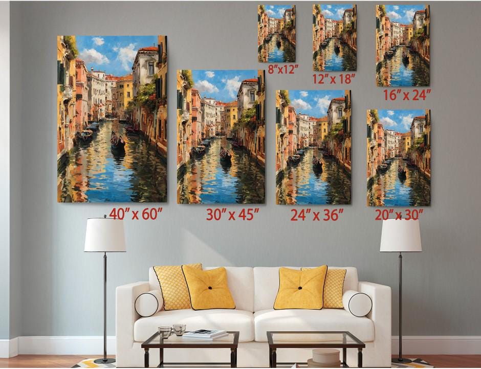 The image is a living room with a white couch and a coffee table. Above the couch, there are six framed paintings of a canal scene, each with a different size and resolution. The paintings are arranged in a grid-like pattern, with each one being a different size, ranging from 40 x 60 to 24 x 36. The paintings are displayed on the wall, and the couch is positioned in front of the coffee table.