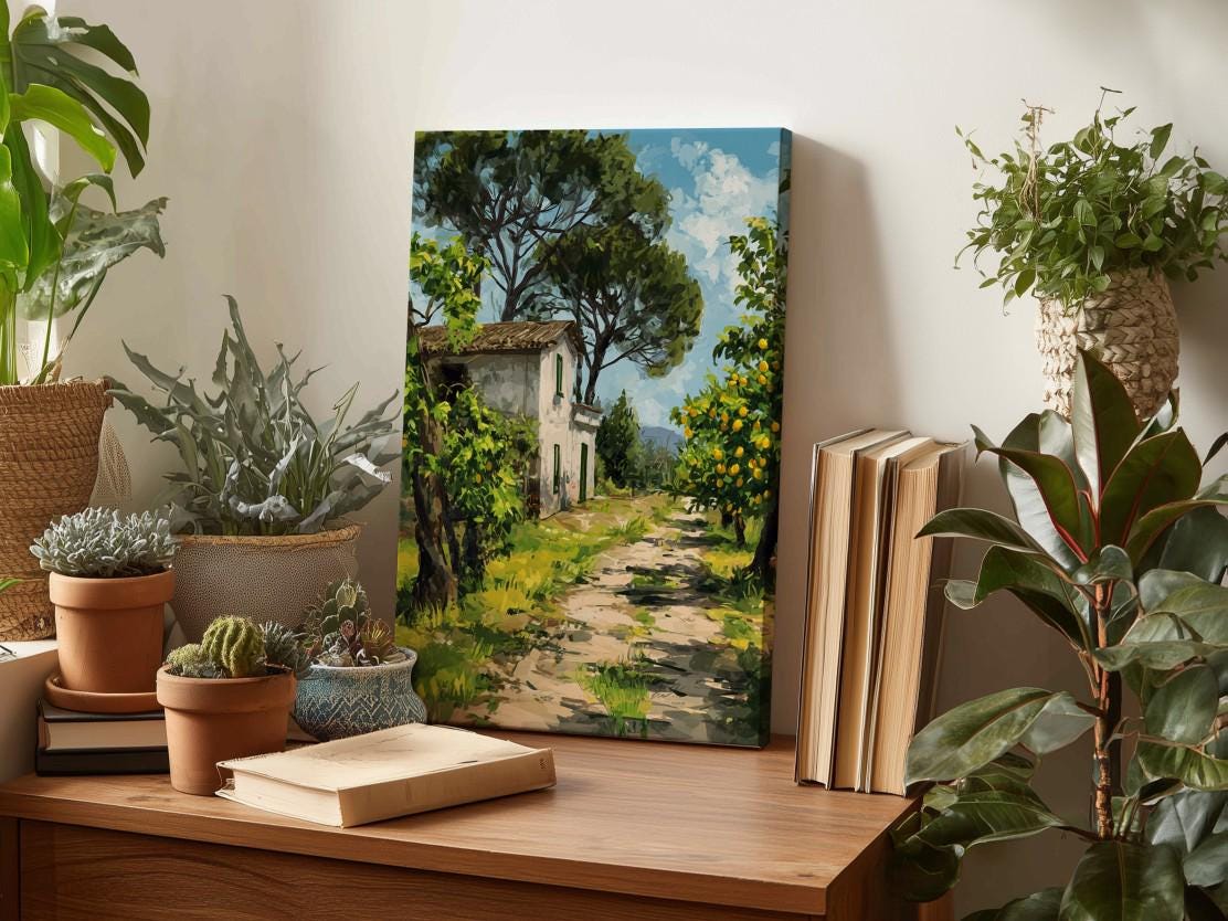 a painting of a house surrounded by lush greenery, including trees and a winding path, displayed on a wooden surface.