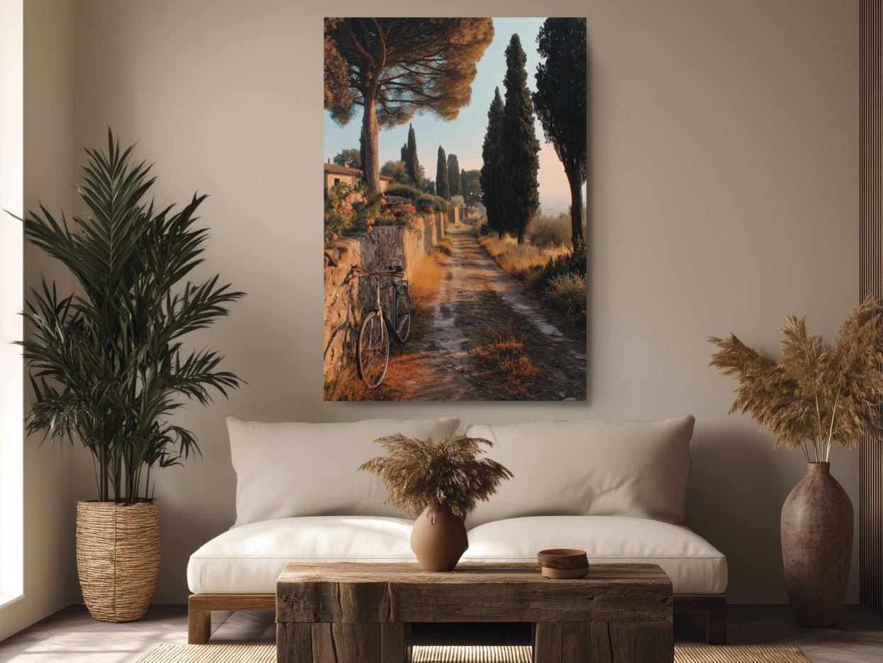 a serene countryside scene with a winding dirt path surrounded by lush greenery and trees. A bicycle is parked on the side of the path, adding a touch of human presence to the natural landscape. The room features a comfortable couch, a wooden coffee table, and two potted plants, creating a cozy and inviting atmosphere.