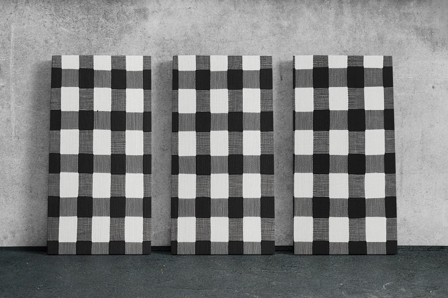three black and white checkered paintings on a wall